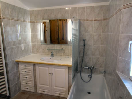Salle de bain compl&egrave;te : baignoire, douche et lavabos, savon liquide, dentifrice, miroir, r&eacute;hausseur pour les enfants ...